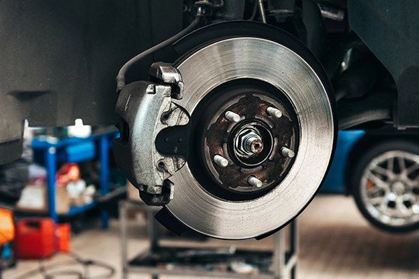 Close-up of brake assembly of vehicle on lift